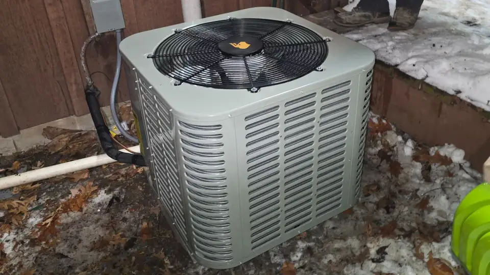 Air conditioner condenser running through an Illinois winter